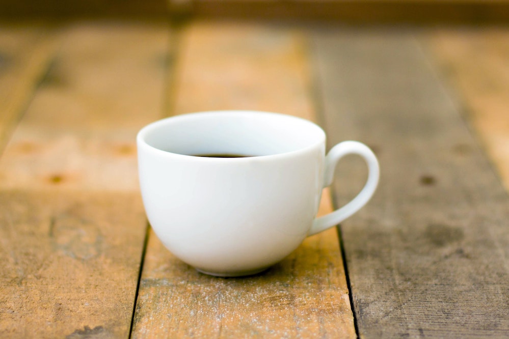 white teacup on a wooden table 